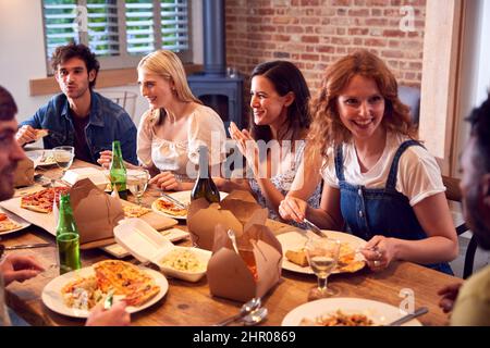 Gruppo multiculturale di amici che si godono insieme birra e pizza Party a casa Foto Stock