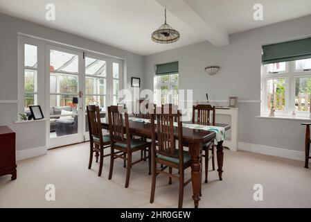 Cavendish, Suffolk - Jan 19 2019: Sala da pranzo decorata in modo semplice e luminosa con tavolo e sedie in legno scuro Foto Stock