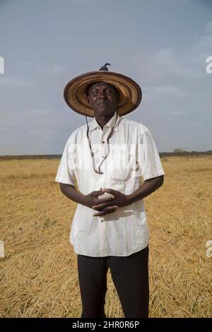 Ritratto di un coltivatore di riso in piedi nel suo campo nel Senegal settentrionale, Africa occidentale. Foto Stock