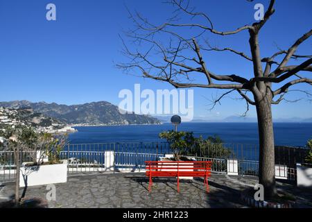 Una panchina rossa che si affaccia sul mare e sulla costiera amalfitana nel villaggio Conca dei Marini, Italia. Foto Stock