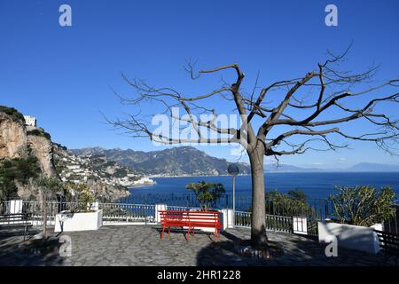 Una panchina rossa che si affaccia sul mare e sulla costiera amalfitana nel villaggio Conca dei Marini, Italia. Foto Stock