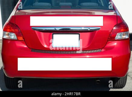 Primo piano orizzontale dell'estremità posteriore di una piccola auto rossa generica con tre cartelli vuoti attaccati. Foto Stock