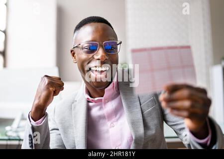 Happy Man guardando il biglietto della lotteria vincente Foto Stock