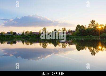 Vista del villaggio di Krpelany che si riflette nel canale del fiume Vah, Slovacchia. Foto Stock
