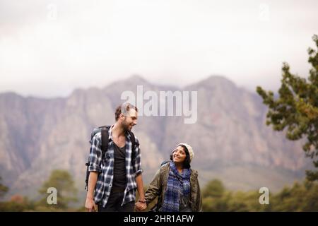 Goditi una passeggiata nella natura. Una giovane coppia carina che esplora insieme l'aria aperta. Foto Stock