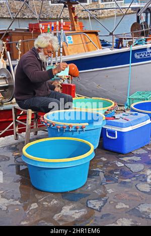 pescatore che lavora nel porto, Grecia, Creta, Elounda Foto Stock
