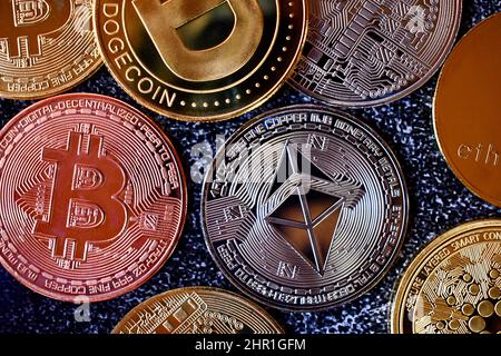 Assortimento di token di criptovaluta visti dall'alto su sfondo scuro Foto Stock