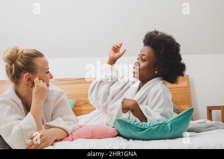 I migliori amici si rilassano al centro benessere e discutono dei segreti Foto Stock