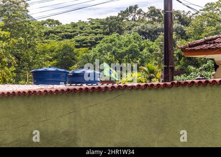 Bandiera brasiliana che vola nel cortile di una casa a Rio de Janeiro, Brasile. Foto Stock