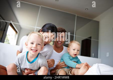 OH no, non si lasceranno andare. Scatto di due ragazzi che trascorrono il tempo in casa con i loro genitori. Foto Stock