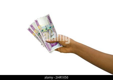 La tenuta di mano giusta 3D ha reso 10000 banconote di franco CFA dell'Africa centrale isolate su sfondo bianco Foto Stock