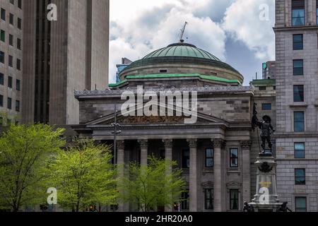 Dettagli architettonici di Place d'Armes, una piazza nel quartiere di Montreal vecchia della città. Nel centro, il monumento in memoria di Paul de Chomedey Foto Stock