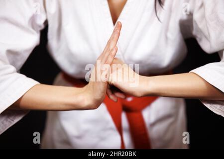 Arco di rispetto. Studio girato di una donna che si inchinava nel suo karate gi. Foto Stock