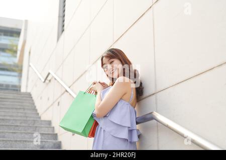 Ritratto di bella ragazza che tiene borse shopping e sorridente Foto Stock