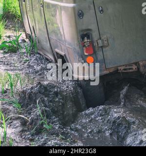 La ruota di un SUV bloccato in fango profondo su una strada di campagna impraticabile Foto Stock