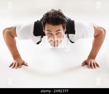 Ottenere il suo corpo in forma. Ritratto di un giovane che fa push-up. Foto Stock