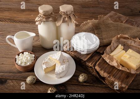 prodotti lattiero-caseari naturali del contadino in assortimento su un rustico tavolo in legno. il concetto di consumo di cibo naturale Foto Stock