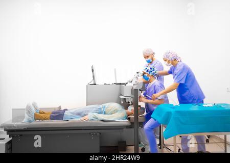 Un team di medici che lavorano insieme per aiutare un paziente Foto Stock