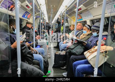 Londra, Regno Unito. 24th Feb 2022. Passeggeri su una carrozza della metropolitana di Londra, molti ora senza maschere facciali.il sindaco di Londra ha annunciato che le facemasks non sono più necessarie per il trasporto pubblico a Londra, portando la capitale in linea con gli sviluppi nazionali dove tutte le restanti restrizioni legali di Covid sono terminate. Credit: Imagplotter/Alamy Live News Foto Stock