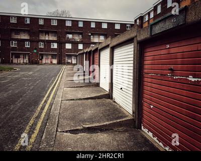 File di garage e case del consiglio in una proprietà immobiliare sociale a Doncaster nel nord dell'Inghilterra durante il livellamento del governo britannico Foto Stock