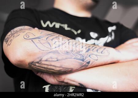 Badass con tatuaggi. Primo piano di un uomo che incrociava le braccia tatuate. Foto Stock