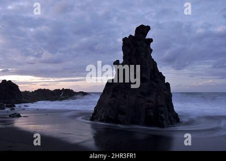 Rocce vulcaniche al tramonto, Playa El Bollullo spiaggia vicino Puerto de la Cruz sulla costa settentrionale di Tenerife Isole Canarie Spagna. Foto Stock