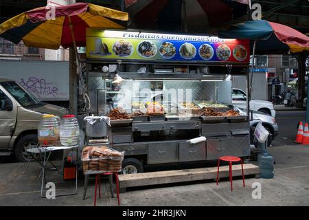PAESAGGIO URBANO. Uno stand gastronomico che vende Picaditas messicane e altri fast food. Sotto il treno el su Roosevelt Avenue a Corona, Queens, New York. Foto Stock