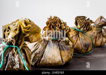 Tradizionale cibo colombiano conosciuto come 'tamales' avvolto con foglie Foto Stock