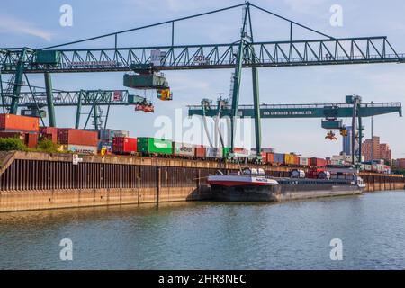 Gru, container e carico intorno al fiume Reno nel porto industriale di Colonia Renania Settentrionale Vestfalia Germania Europa Foto Stock