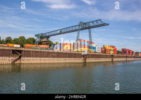 Gru, container e carico intorno al fiume Reno nel porto industriale di Colonia Renania Settentrionale Vestfalia Germania Europa Foto Stock