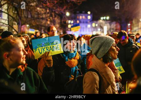 Un membro della comunità Ucraina ha visto tenere un cartello con la scritta "Stand with Ukraine” durante la manifestazione. Dopo l'inizio dell'invasione russa dell'Ucraina, membri della comunità Ucraina e polacchi e bielorussi di sostegno hanno protestato presso le missioni diplomatiche della Federazione russa per esprimere la loro opposizione all'aggressione militare russa. A Cracovia, dove l'immigrazione Ucraina è particolarmente numerosa, diverse migliaia di persone si sono radunate davanti al consolato russo. (Foto di Filip Radwanski / SOPA Images/Sipa USA) Foto Stock