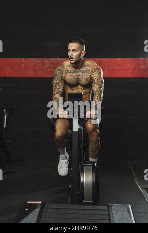 Giovane attraente uomo caucasico esercitarsi in palestra Foto Stock