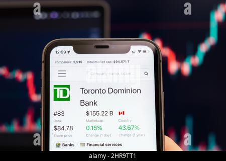 Toronto Dominion Bank stock price sullo schermo del telefono cellulare in mano mans con cambio di borsa con trading candlestick grafico analisi, febbraio 2022, San Francisco, Stati Uniti Foto Stock