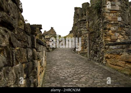 Percorso in mattoni con muri in pietra per il Castello di Scarborough Foto Stock