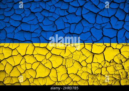 Ucraina bandiera nazionale blu e gialla su una struttura di fango di fessure secche sul terreno Foto Stock