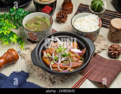 Speziato scrigante fritto Chongqing Squid Casserole con riso e zuppa isolato sul mate vista superiore del tavolo cinese cibo Foto Stock