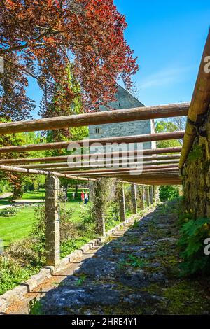 Wooden logs over a pathway against a building Stock Photo