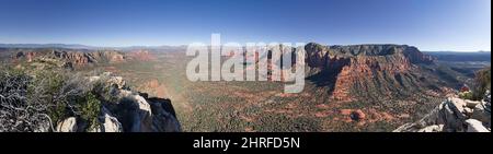 Panorama che domina l'area di roccia rossa di Sedona Arizona dalla cima del tribunale Butte con la donna che si avvicina alla cima sul lato Foto Stock