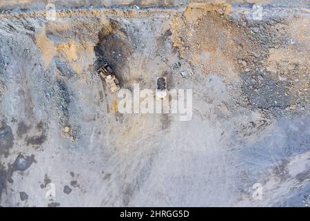 Grande camion giallo all'interno di una cava di granito per caricare camion di scarico di scavo industriale Foto Stock