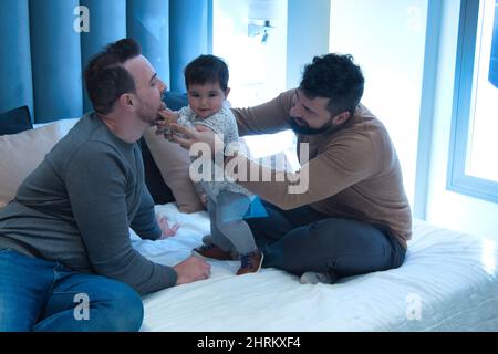 Primo piano di una coppia gay sposata che gioca con la loro figlia Foto Stock