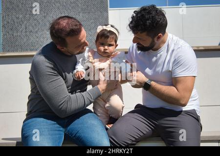 Primo piano di una coppia gay sposata che gioca con la loro figlia Foto Stock