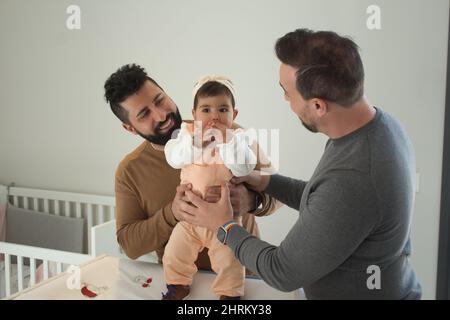 Primo piano di una coppia gay sposata che gioca con la loro figlia Foto Stock