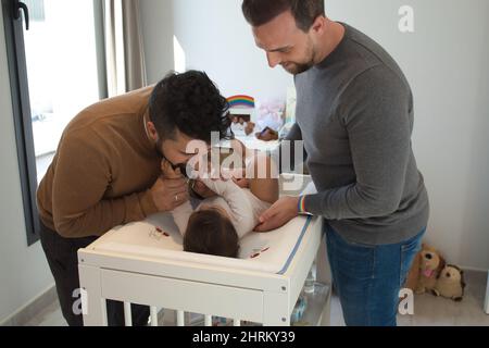 Primo piano di una coppia gay sposata che gioca con la loro figlia Foto Stock