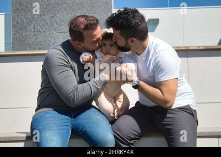 Primo piano di una coppia gay sposata che gioca con la loro figlia Foto Stock