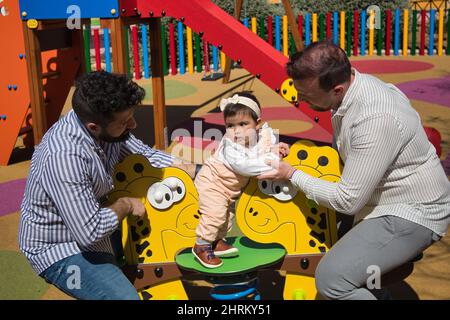 Primo piano di una coppia gay sposata che gioca con la loro figlia Foto Stock