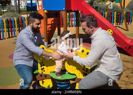 Primo piano di una coppia gay sposata che gioca con la loro figlia Foto Stock