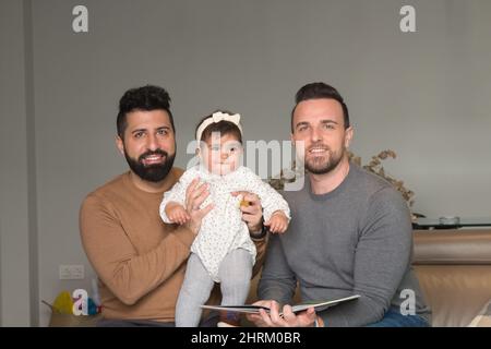 Primo piano di una coppia gay sposata che gioca con la loro figlia Foto Stock