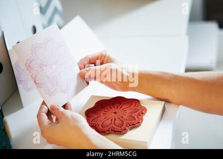 La pratica rende perfetto. Scatto ritagliato di una donna con le mani che reggono una carta artigianale. Foto Stock