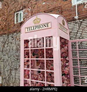 Cabina telefonica rosa decorata con fiori in Corea del Sud Foto Stock