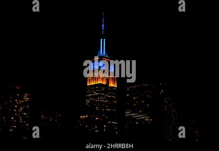 New York, Stati Uniti. 25th Feb 2022. 25 Febbraio 2022 - New York City, New York, Stati Uniti: L'Empire state Building di New York City è illuminato nei colori giallo e blu della bandiera Ukraniana venerdì sera, 25 febbraio. Credit: Adam Stoltman/Alamy Live News Foto Stock